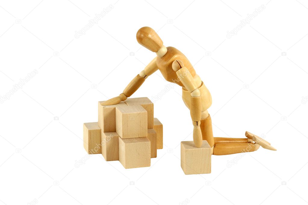 Wooden manikin playing with blocks