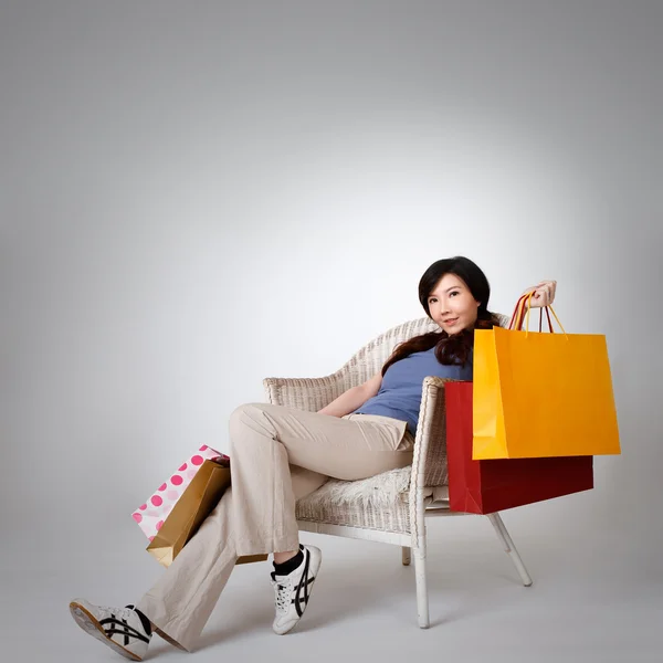 Mujer de compras sentada en silla — Foto de Stock