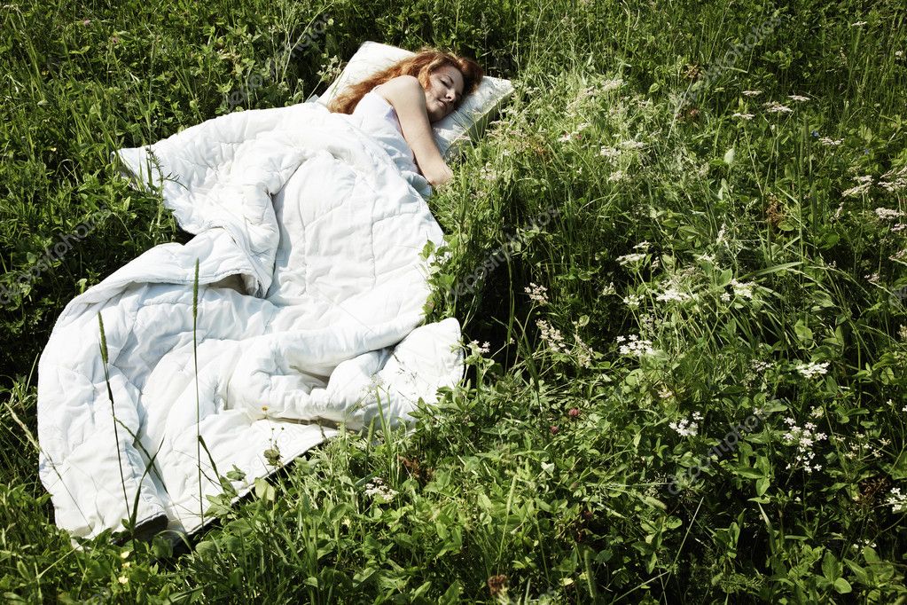 Portrait of the sleeping young woman on a meadow