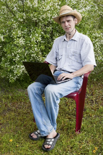 A young man in a cherry garden — Stock Photo, Image