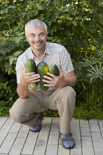 Zadowolony człowiek z trzech zucchin — Zdjęcie stockowe
