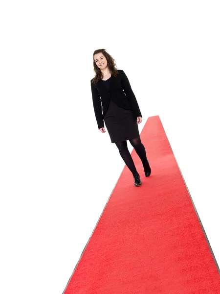 Lachende meisje lopen op rood tapijt — Stockfoto
