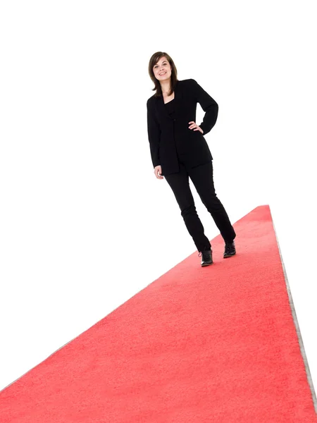 Smiling girl walking on red carpet — Stock Photo, Image