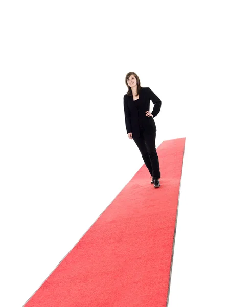 Chica sonriente caminando sobre alfombra roja — Foto de Stock
