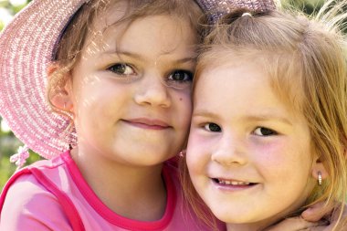 Two happy little girls hugging clipart