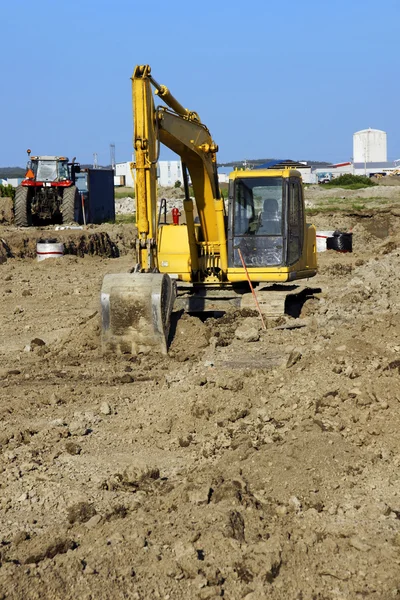 Excavadora amarilla y tractor vertical — Foto de Stock
