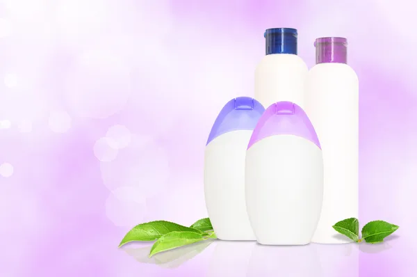 Cuatro botellas de cosméticos en blanco — Foto de Stock