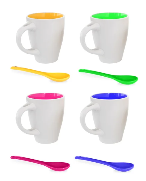 Fyra färgglada muggar för te eller kaffe och fyra färgglada skedar — Stockfoto