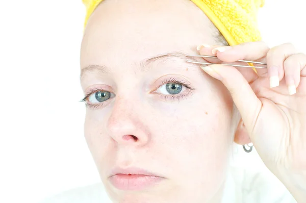 Junge Frau putzt ihre Augenbrauen — Stockfoto