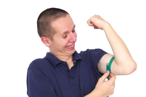 Young skinny man measuring his muscle — Stock Photo, Image