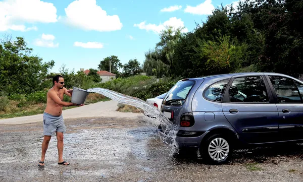 stock image Young man washing the car