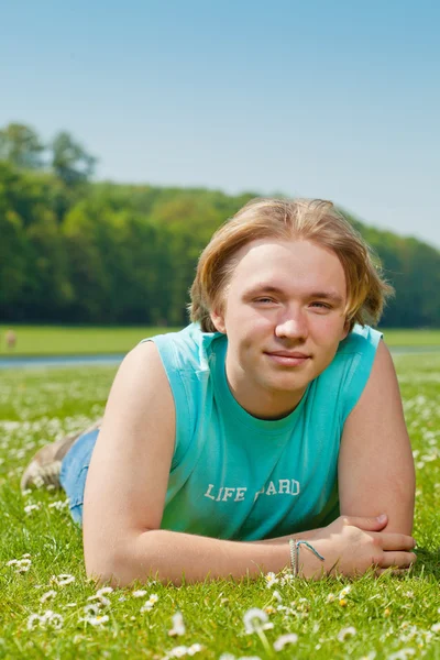 Adolescente chico acostado en la hierba — Foto de Stock
