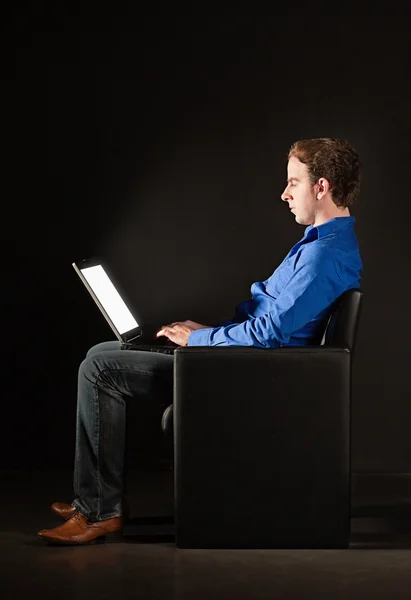 Young man with laptop in the dark — Stock Photo, Image