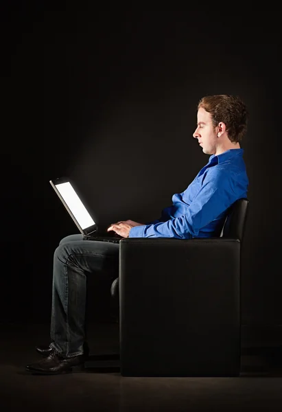 어둠 속에서 노트북으로 젊은 남자 — 스톡 사진