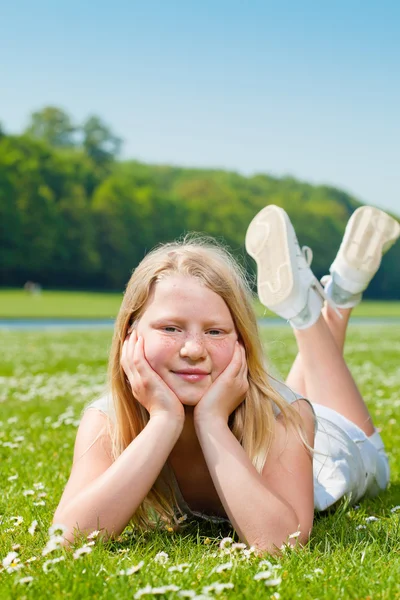 Tiener meisje liggen op het gras — Stockfoto