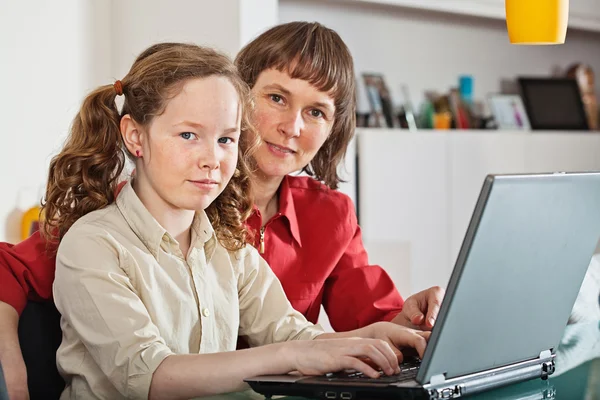 Ragazza e sua madre con computer portatile a casa — Foto Stock