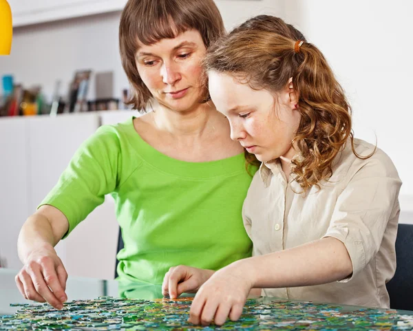 Mädchen und Mutter beim Puzzle — Stockfoto