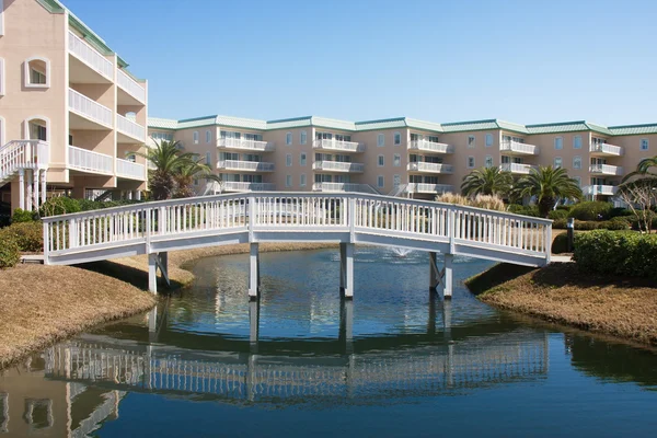 stock image Wood Bridge Over Blue Lagoon in Luxury Condo Complex