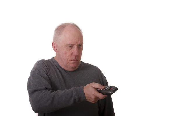 Hombre calvo mayor con camisa gris que trabaja el control remoto —  Fotos de Stock