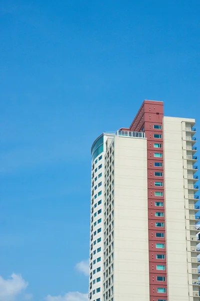 Kırmızı ve beyaz apartman kule mavi gökyüzü — Stok fotoğraf