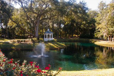 Gazebo by Fountain in Lake Past Roses clipart