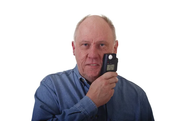 Старший чоловік у блакитній сорочці тримає лічильник світла обличчям — стокове фото