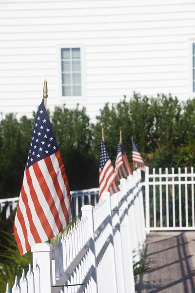 Американские флаги на заборе для белого пикета — стоковое фото