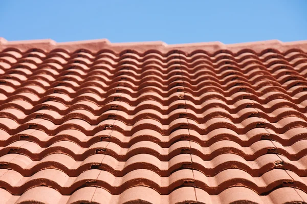 Telhado de telha vermelha sob céu azul — Fotografia de Stock