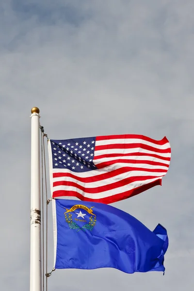 Nevada ve Amerikan bayrakları direğe gökyüzü altında — Stok fotoğraf