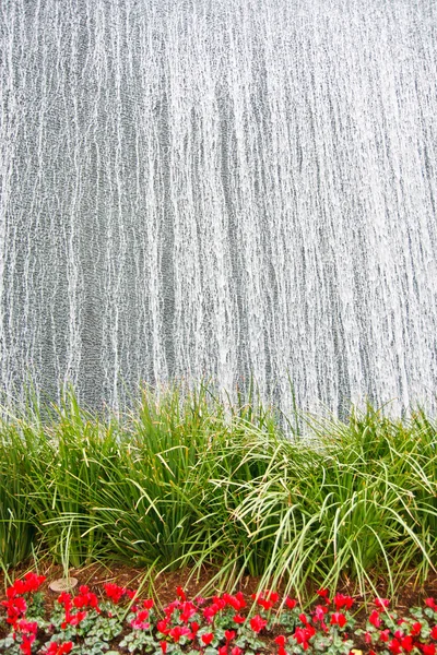 Фонтан серебряной воды над садом — стоковое фото