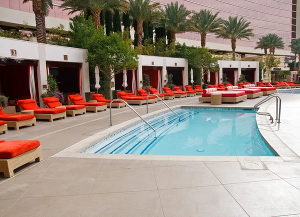 Stock image Wading Pool at Resort with Orange Chaise Lounges