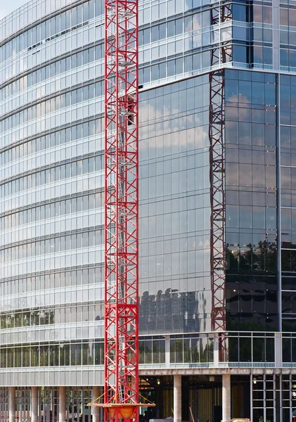 Grúa roja en frente de la construcción de vidrio —  Fotos de Stock