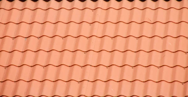 Красная крыша из изогнутых плиток — стоковое фото