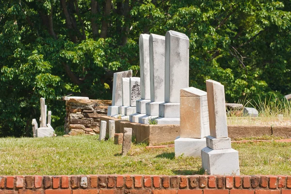 Staré žulové náhrobky cihlová zeď — Stock fotografie