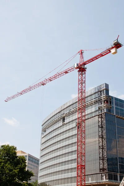 Grúa roja por nuevo edificio de construcción de vidrio —  Fotos de Stock