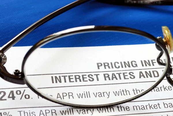 Focus sur le taux d'intérêt dans une divulgation de carte de crédit isolé sur bleu — Photo