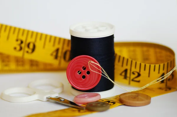 Sommige naaien hulpmiddelen zoals threads, naalden, knoppen en schaar — Stockfoto