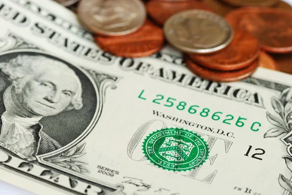 Vista de perto da conta de um dólar e algumas moedas — Fotografia de Stock