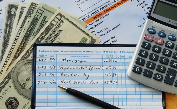 Schreiben Sie einige Schecks, um Zahlungen für Haushaltsausgaben zu leisten Stockbild