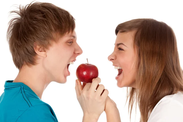 Мальчик и девочка кусают яблоко — стоковое фото