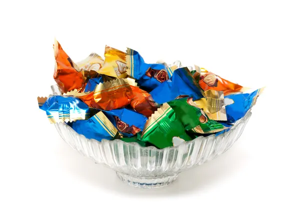 Glazen vaas met snoep in kleurrijke wrappers — Stockfoto