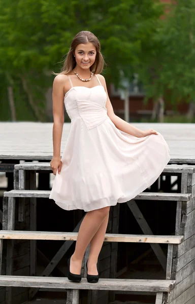 Girl on the stairs in a dress — Stock Photo, Image