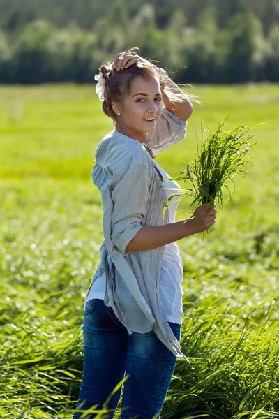 Dívka s balíkem zelené trávy — Stock fotografie