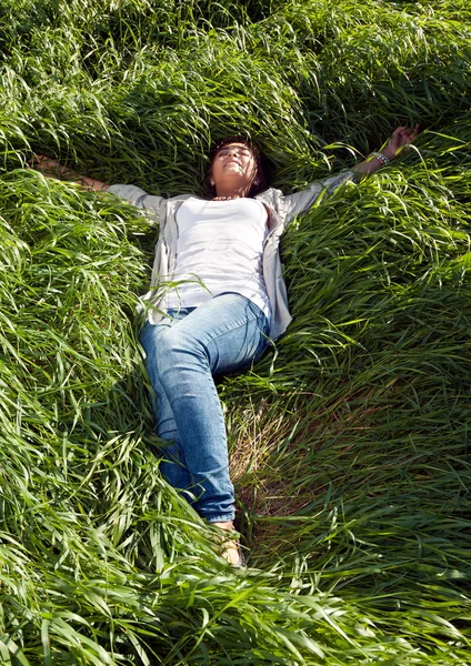 Fille couchée dans l'herbe verte — Photo