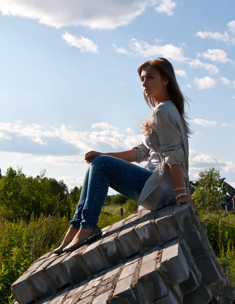 Schönes Mädchen sitzt auf den Ruinen — Stockfoto