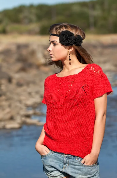 Schönes Mädchen in rotem Pullover und Jeanshose — Stockfoto