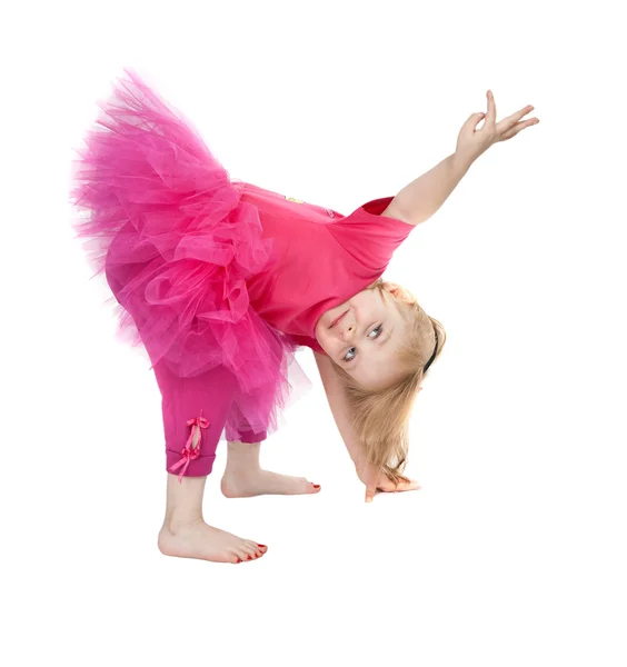 Liten flicka i en rosa klänning dans i studion fören — Stockfoto