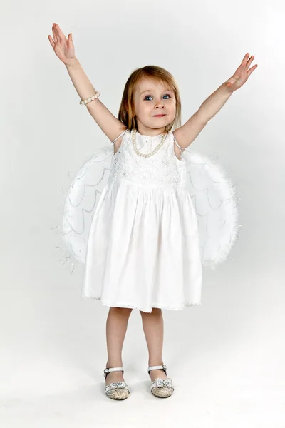 Маленькая девочка с ангельскими крыльями в студии — стоковое фото