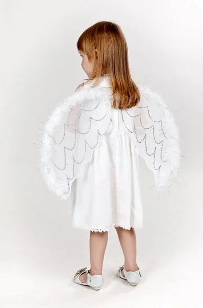 Dziewczynka z anielskimi skrzydłami w studio — Zdjęcie stockowe