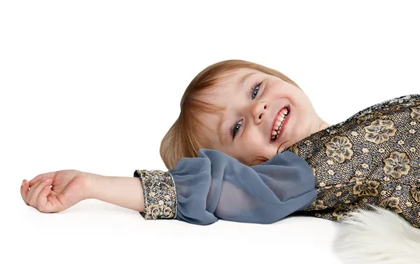 Klein meisje liggend op de vloer in de studio — Stockfoto